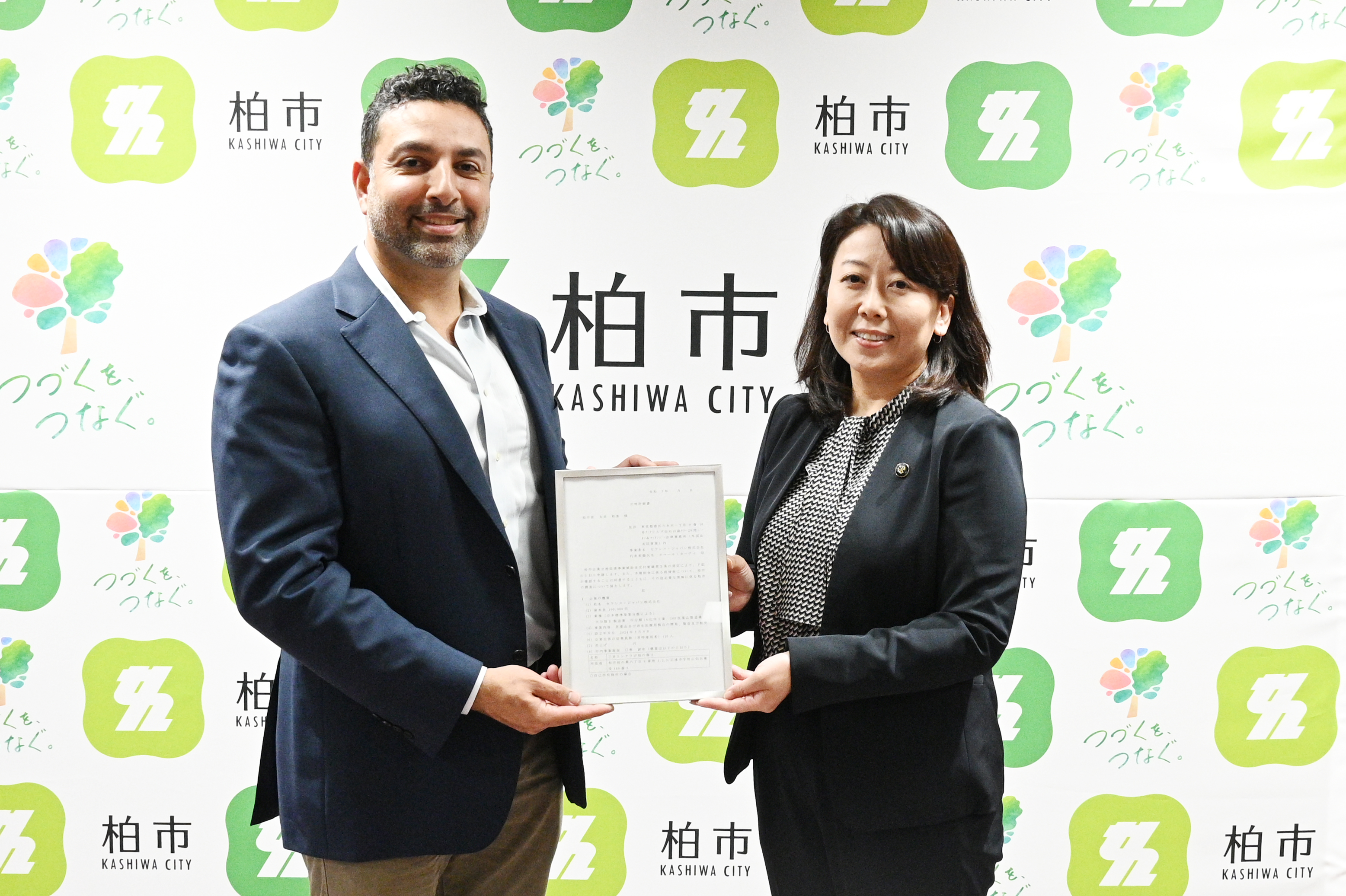 オマル氏と市長の写真（立地計画書提出の様子）