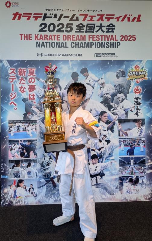 トロフィーを持ってポーズを決める早坂さん
