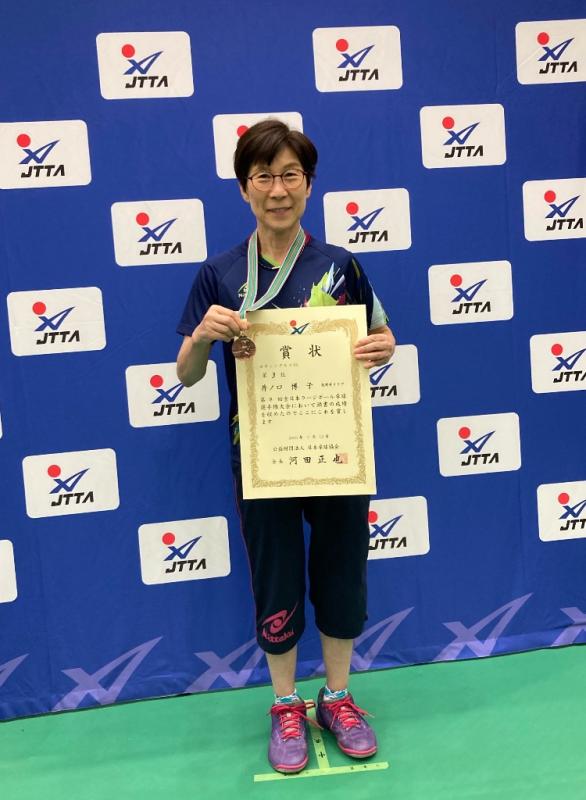 メダルと賞状を掲げる井ノ口さん