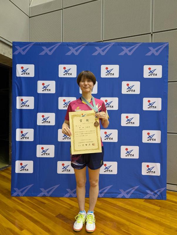 メダルと賞状を掲げる中田さん