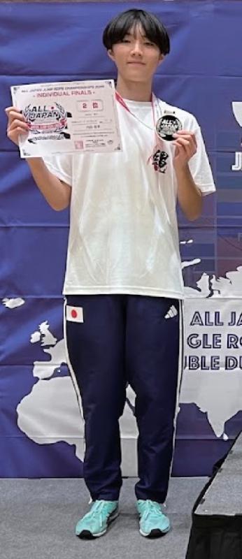 メダルと賞状を掲げる内田さん